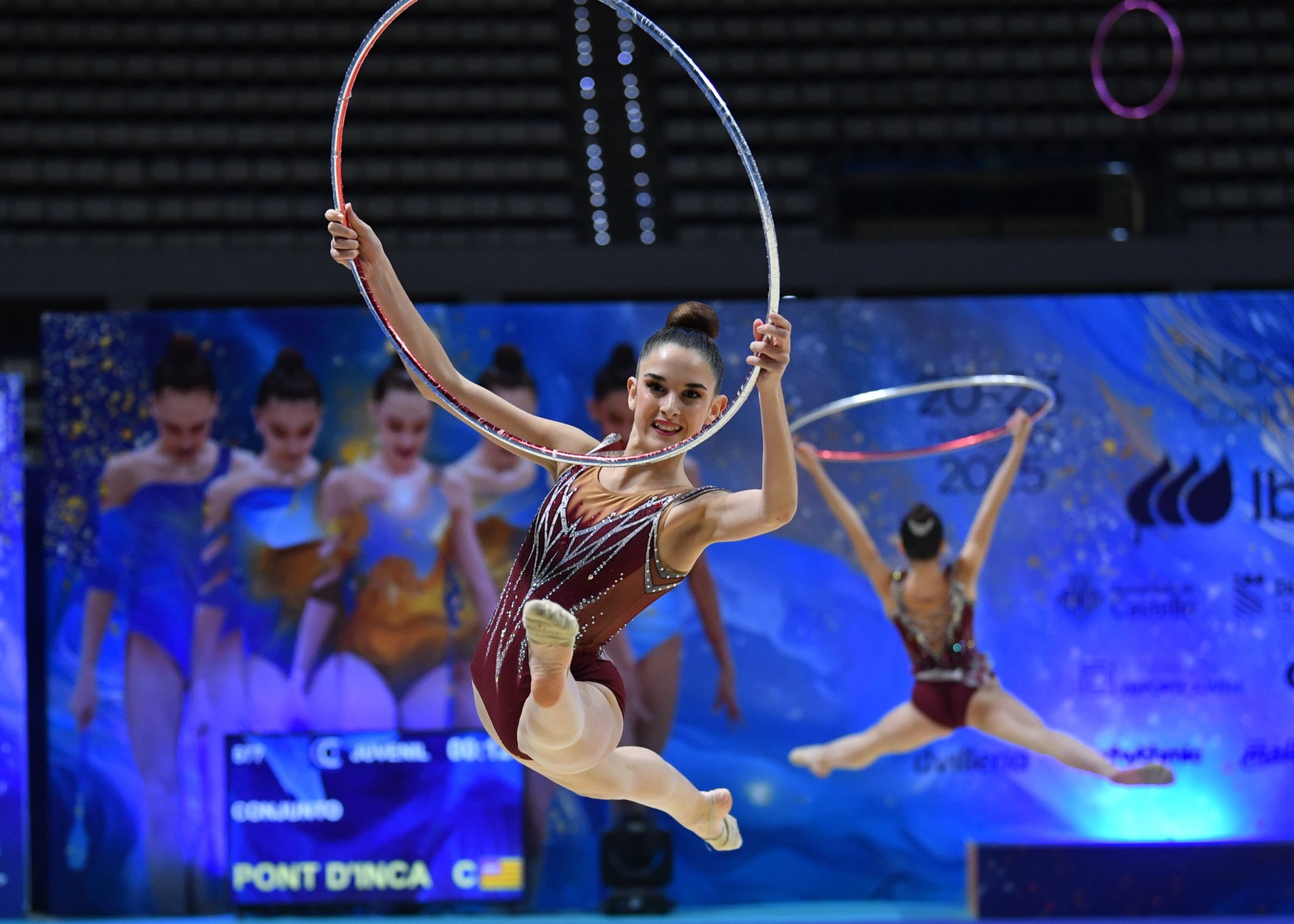 Gimnasta de Rítmica Boadilla en el aire con el aro durante una competición nacional